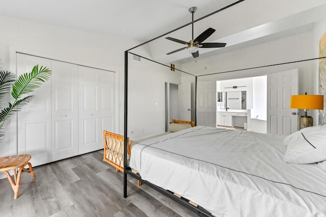bedroom featuring ensuite bath, wood finished floors, a closet, and a ceiling fan