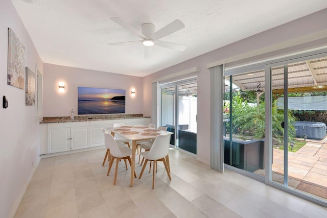 dining space featuring ceiling fan and baseboards