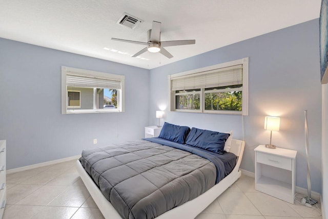 bedroom with baseboards, a ceiling fan, visible vents, and light tile patterned floors