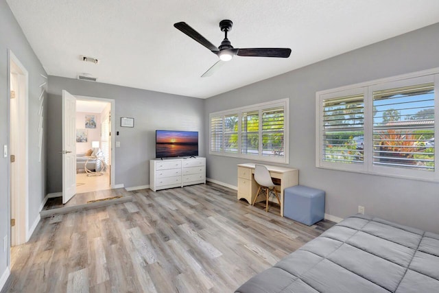 bedroom with light wood-type flooring, visible vents, baseboards, and ceiling fan