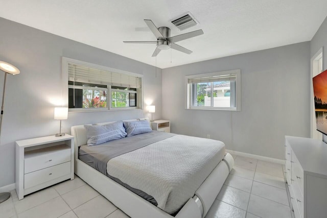 bedroom with baseboards, visible vents, ceiling fan, and light tile patterned flooring