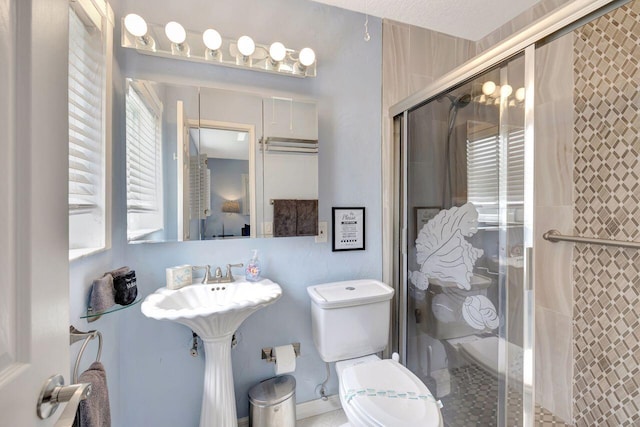 bathroom featuring toilet and a stall shower