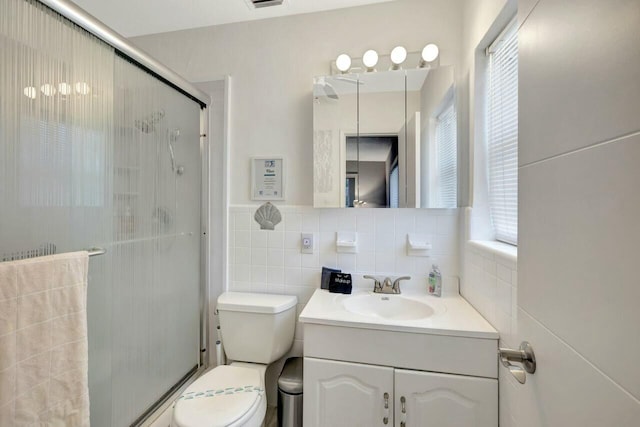 full bath featuring toilet, a healthy amount of sunlight, vanity, and a stall shower