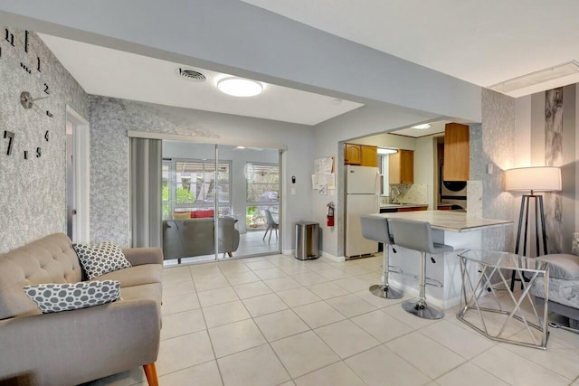 living area featuring visible vents and light tile patterned floors