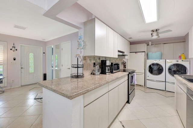 kitchen with light tile patterned floors, appliances with stainless steel finishes, backsplash, under cabinet range hood, and independent washer and dryer