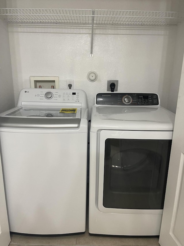 clothes washing area featuring washer and clothes dryer and laundry area