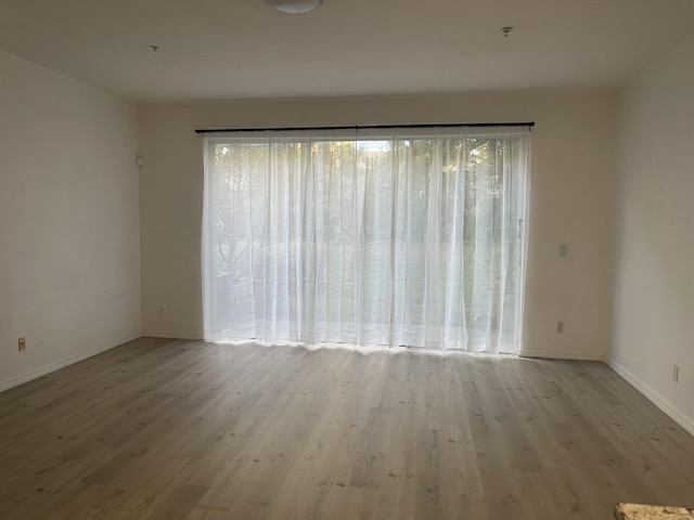 spare room featuring wood finished floors and baseboards