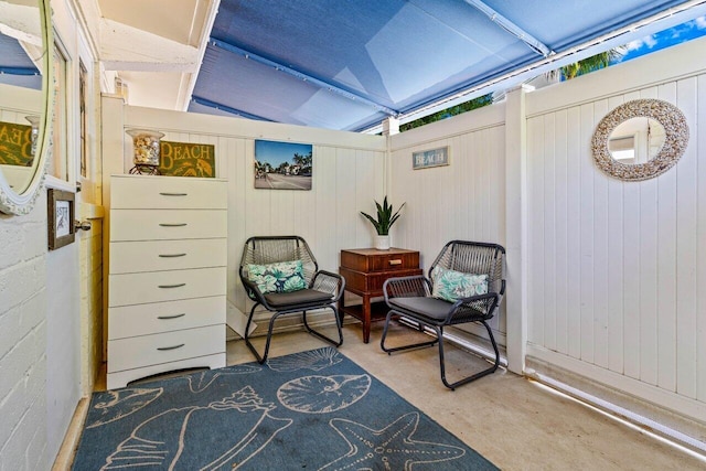 sitting room with concrete flooring and lofted ceiling