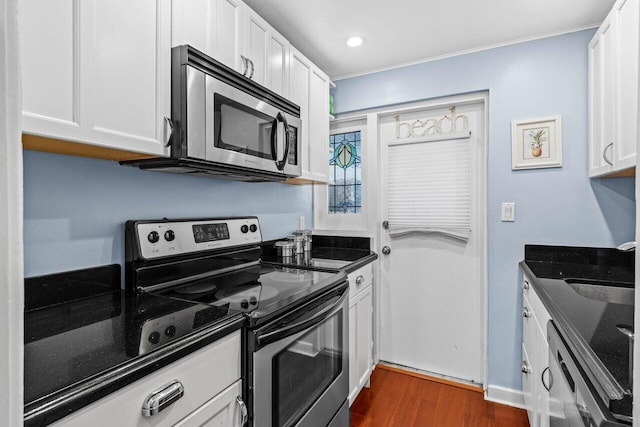 kitchen with dark wood-style floors, white cabinets, and appliances with stainless steel finishes