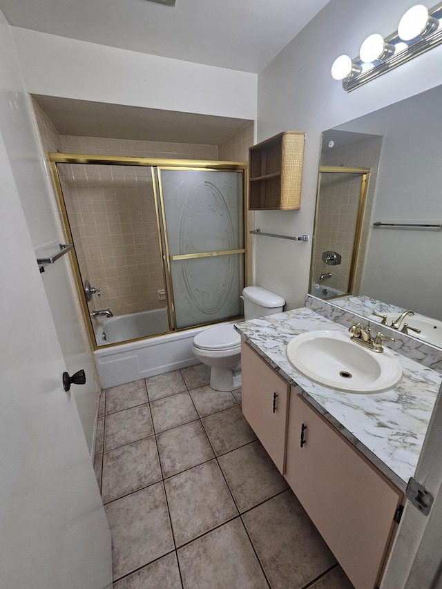 full bathroom with tile patterned floors, toilet, vanity, and shower / bath combination with glass door