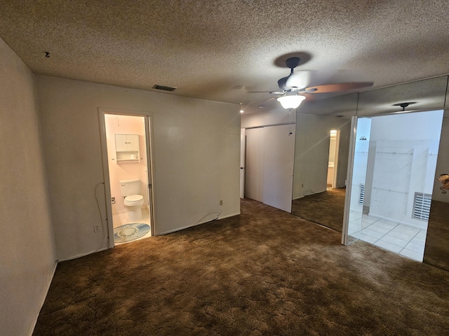 empty room with ceiling fan, carpet flooring, visible vents, and a textured ceiling