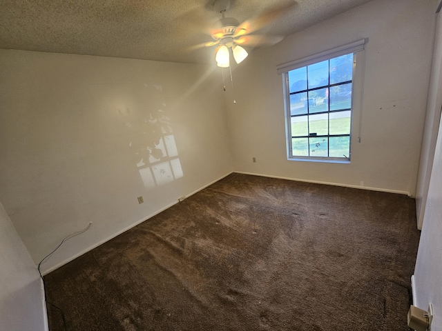 empty room featuring ceiling fan, baseboards, dark colored carpet, and a textured ceiling