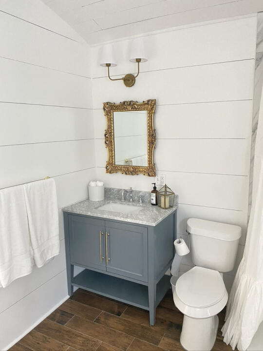 bathroom with vaulted ceiling, toilet, vanity, and wood finished floors