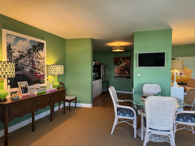 carpeted dining room with baseboards