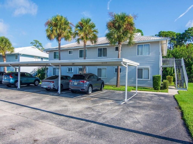 217 SE Village Dr Unit 217, Port Saint Lucie, FL 34952 - exterior space with covered parking, stairs, and metal roof