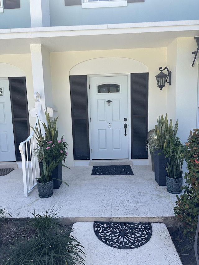 property entrance with stucco siding