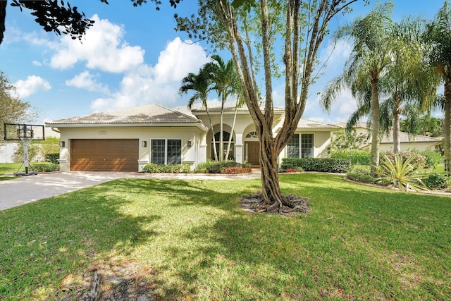 ranch-style house with driveway, stucco siding, a front lawn, a garage, and a tiled roof