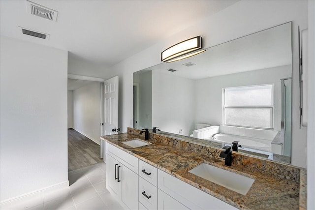 bathroom featuring a bath, visible vents, and a sink