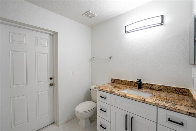 bathroom featuring visible vents, a textured ceiling, toilet, and vanity