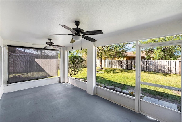 unfurnished sunroom featuring a healthy amount of sunlight and a ceiling fan