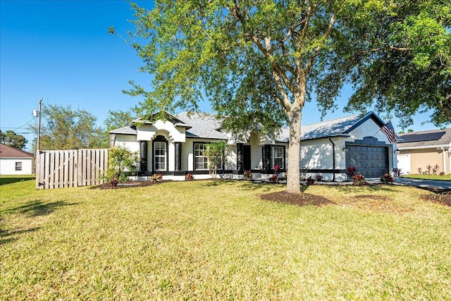 view of front of house featuring a front yard, fence, driveway, stucco siding, and a garage