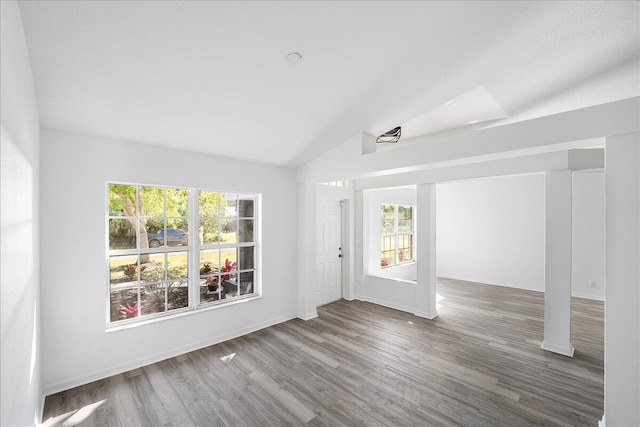 empty room with lofted ceiling, wood finished floors, and baseboards