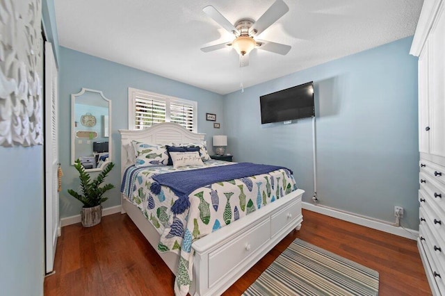 bedroom featuring dark wood-style floors, a ceiling fan, and baseboards