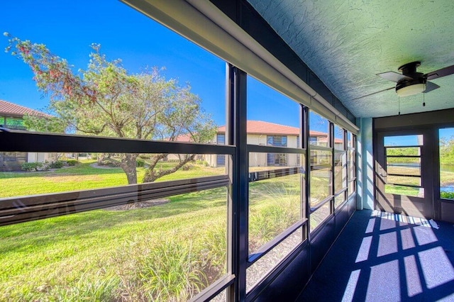 unfurnished sunroom featuring ceiling fan