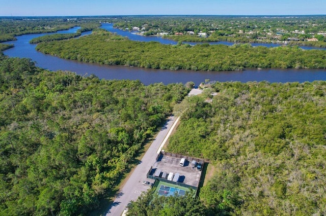 drone / aerial view with a forest view and a water view