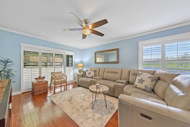 living area featuring hardwood / wood-style flooring, crown molding, baseboards, and ceiling fan