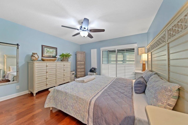 bedroom with ceiling fan, baseboards, and wood finished floors