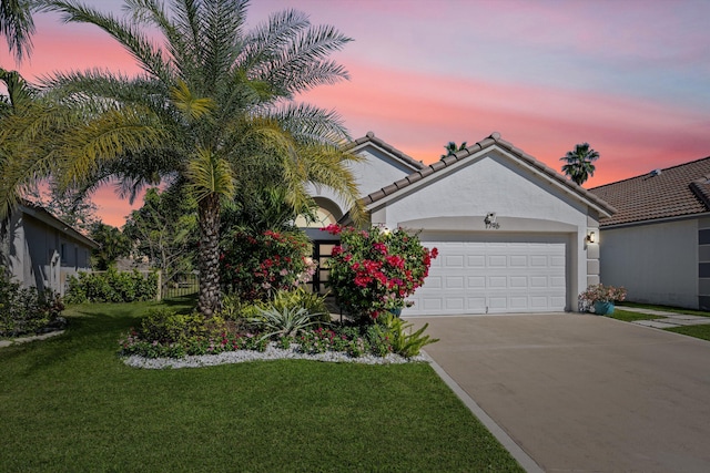 view of front of house featuring a lawn, concrete driveway, a garage, and stucco siding