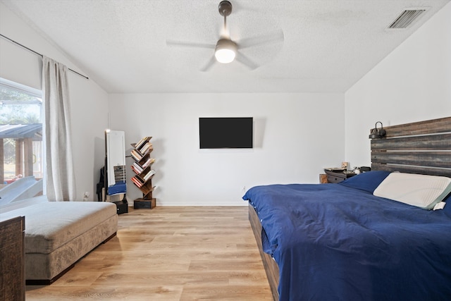 bedroom featuring visible vents, light wood finished floors, and a textured ceiling