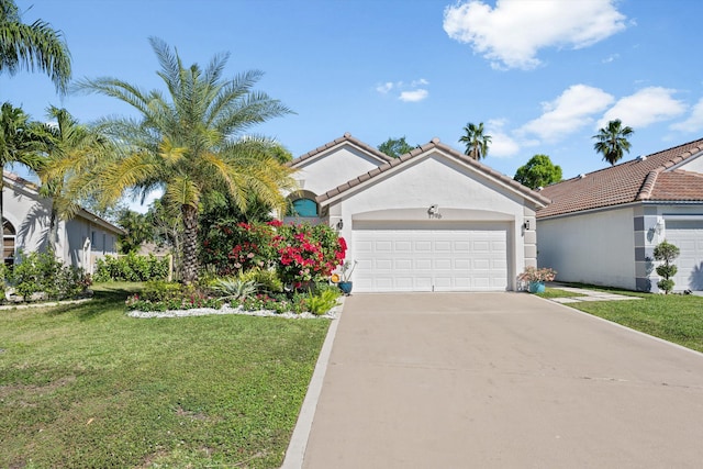 view of front of property featuring a front lawn, an attached garage, a tile roof, and stucco siding