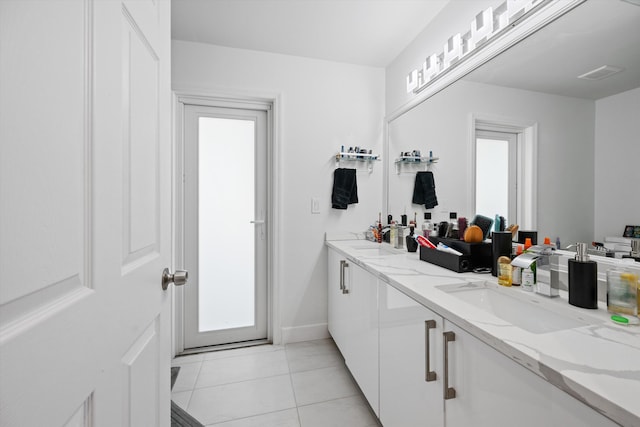 bathroom with tile patterned floors, visible vents, double vanity, and a sink