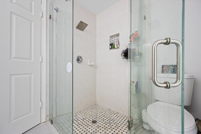 bathroom with a shower stall and toilet