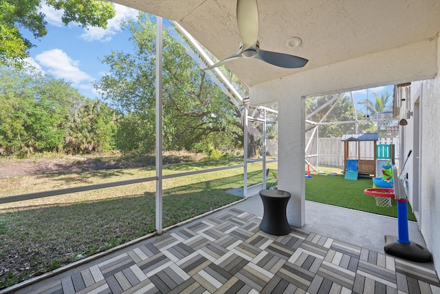 unfurnished sunroom with ceiling fan