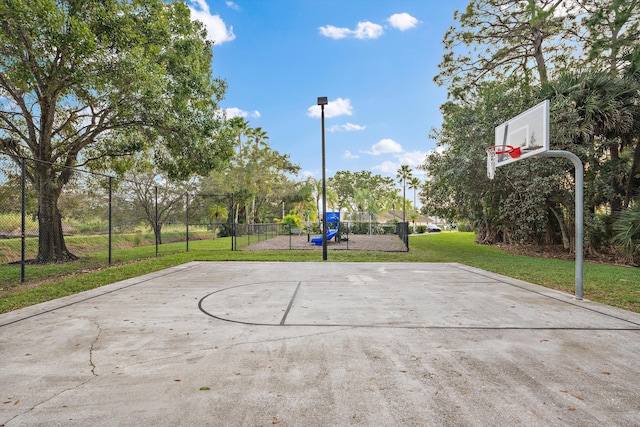 view of basketball court featuring community basketball court, a lawn, playground community, and fence