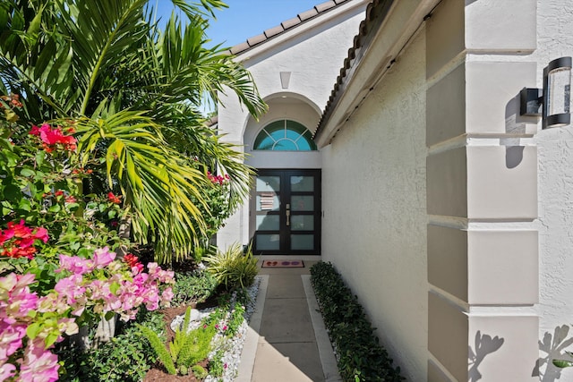 doorway to property with a tiled roof and stucco siding