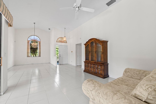 living room with light tile patterned floors, visible vents, ceiling fan with notable chandelier, and high vaulted ceiling