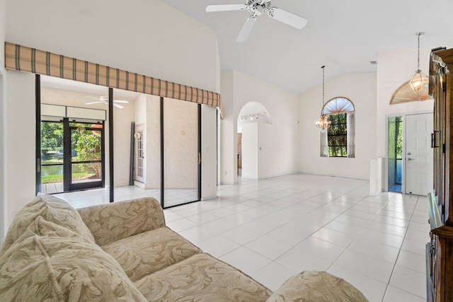 living room with light tile patterned flooring, ceiling fan with notable chandelier, a wealth of natural light, and high vaulted ceiling