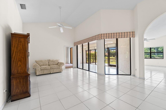 tiled living room featuring arched walkways, visible vents, high vaulted ceiling, and a ceiling fan