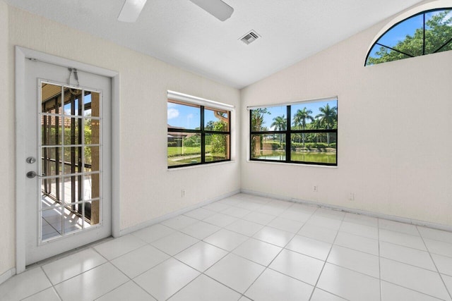 tiled spare room with lofted ceiling, a ceiling fan, visible vents, and baseboards