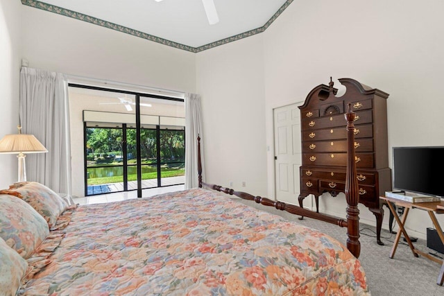 carpeted bedroom featuring access to outside, a ceiling fan, baseboards, and a towering ceiling