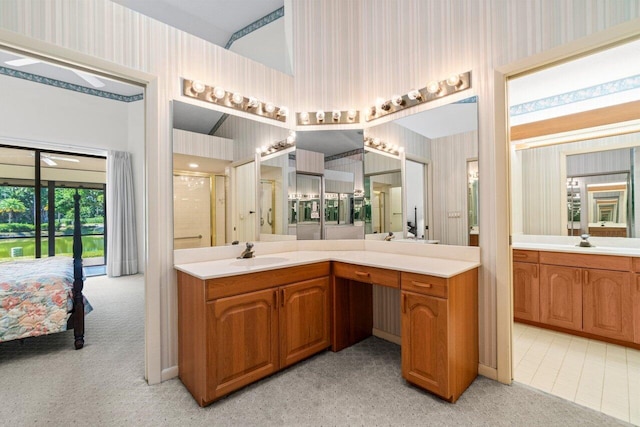 ensuite bathroom featuring a shower stall, wallpapered walls, vanity, and connected bathroom