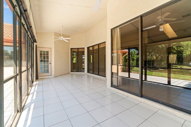 unfurnished sunroom with vaulted ceiling, plenty of natural light, and a ceiling fan