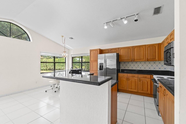 kitchen with visible vents, dark countertops, appliances with stainless steel finishes, brown cabinetry, and lofted ceiling