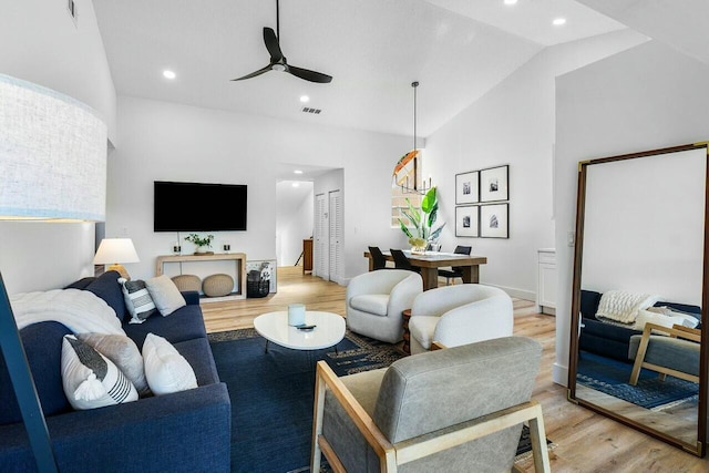 living area featuring a ceiling fan, visible vents, lofted ceiling, light wood-style flooring, and recessed lighting