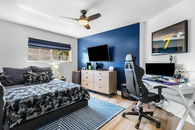 bedroom with light wood finished floors, a textured ceiling, and ceiling fan