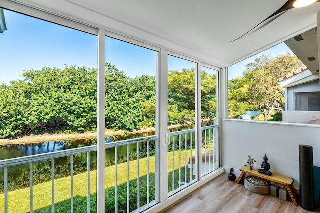 sunroom featuring a healthy amount of sunlight and a water view